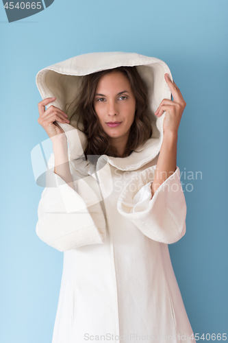 Image of woman in a white coat with hood isolated on blue background