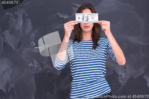 Image of woman holding a banknote in front of chalk drawing board