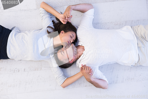 Image of handsome couple lying on floor