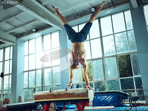 Image of The sportsman during difficult exercise, sports gymnastics