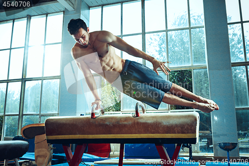 Image of The sportsman during difficult exercise, sports gymnastics