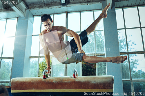 Image of The sportsman during difficult exercise, sports gymnastics