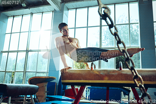 Image of The sportsman during difficult exercise, sports gymnastics