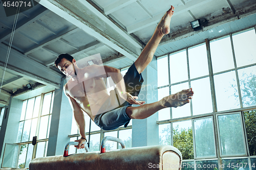 Image of The sportsman during difficult exercise, sports gymnastics