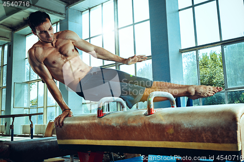 Image of The sportsman during difficult exercise, sports gymnastics