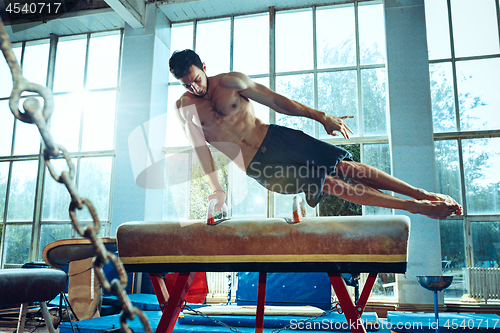 Image of The sportsman during difficult exercise, sports gymnastics