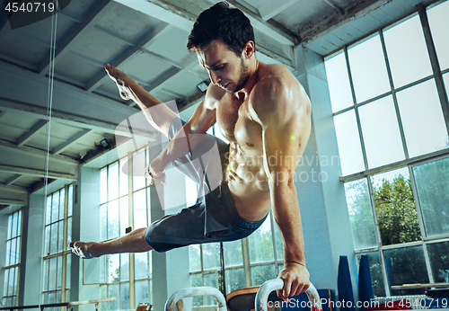 Image of The sportsman during difficult exercise, sports gymnastics