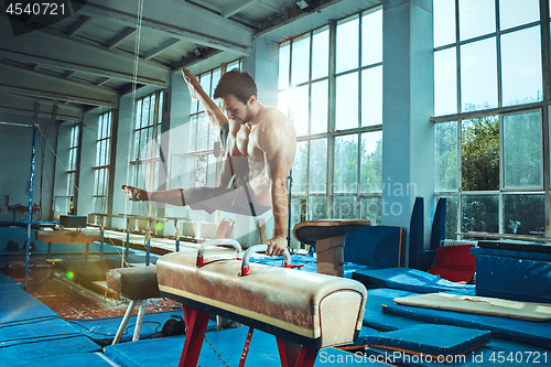 Image of The sportsman during difficult exercise, sports gymnastics