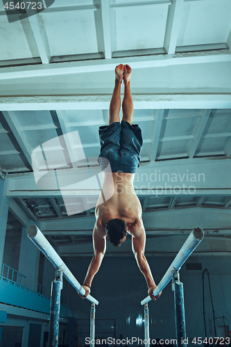 Image of The sportsman during difficult exercise, sports gymnastics