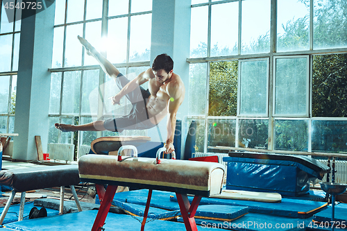 Image of The sportsman during difficult exercise, sports gymnastics