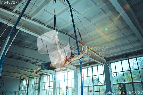 Image of The sportsman during difficult exercise, sports gymnastics