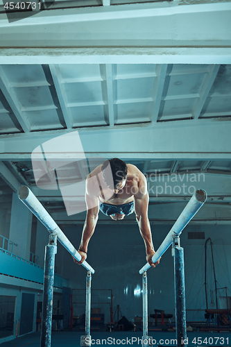 Image of The sportsman during difficult exercise, sports gymnastics