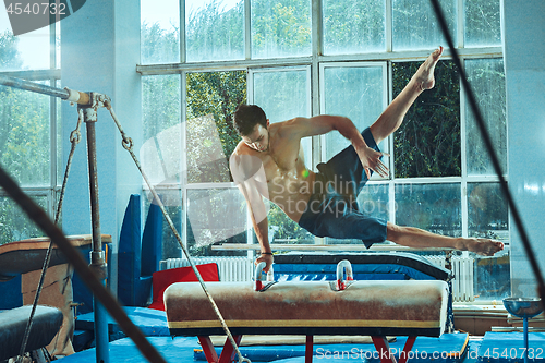 Image of The sportsman during difficult exercise, sports gymnastics