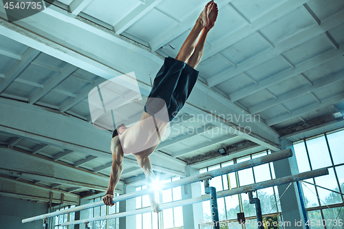 Image of The sportsman during difficult exercise, sports gymnastics