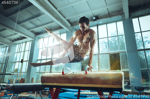 Image of The sportsman during difficult exercise, sports gymnastics