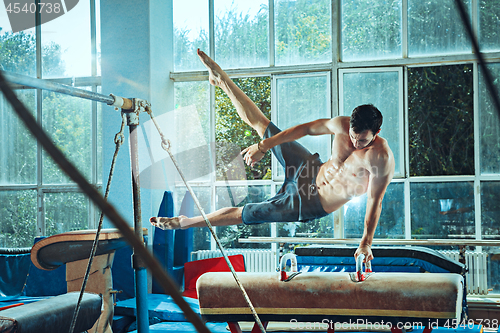 Image of The sportsman during difficult exercise, sports gymnastics