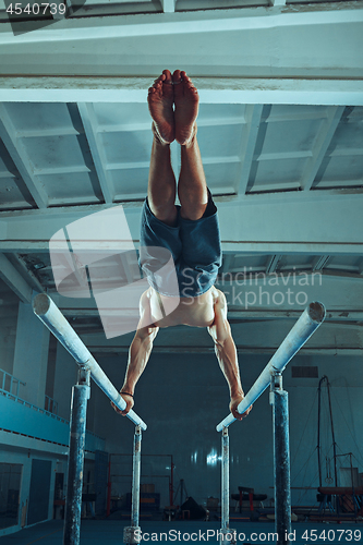 Image of The sportsman during difficult exercise, sports gymnastics