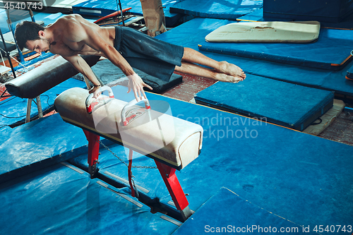 Image of The sportsman during difficult exercise, sports gymnastics