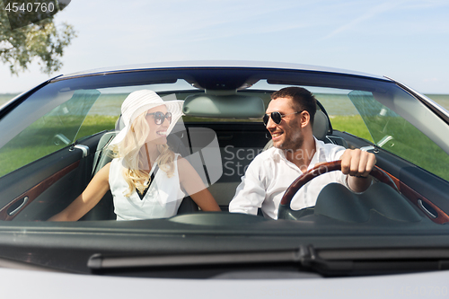 Image of happy man and woman driving in cabriolet car