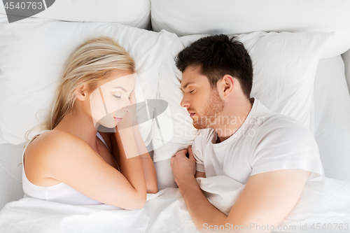 Image of happy couple sleeping in bed at home