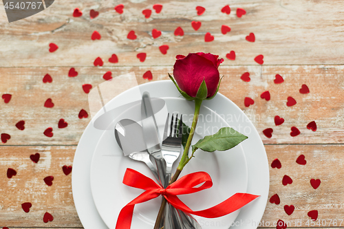 Image of close up of red rose flower on set of dishes