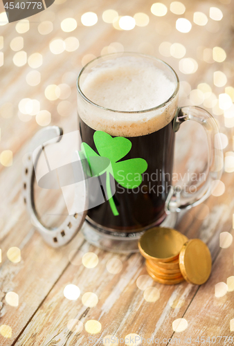 Image of shamrock on glass of beer, horseshoe and coins