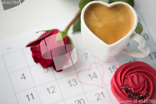 Image of close up of calendar, coffee, cupcake and red rose