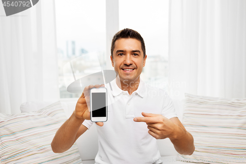 Image of happy man with smartphone at home