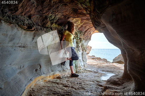 Image of Woman standing in sandstone cave and tunnel 