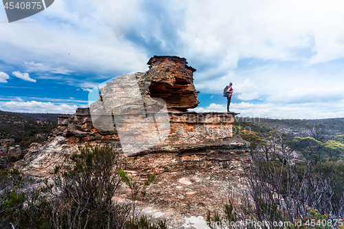 Image of Female explorer standing on top of pagoda with cave and balcony