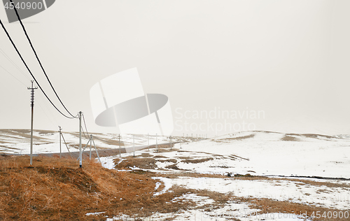 Image of Winter field with power line columns