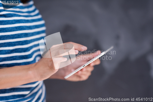 Image of woman using tablet  in front of chalk drawing board