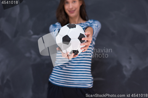 Image of woman holding a soccer ball in front of chalk drawing board