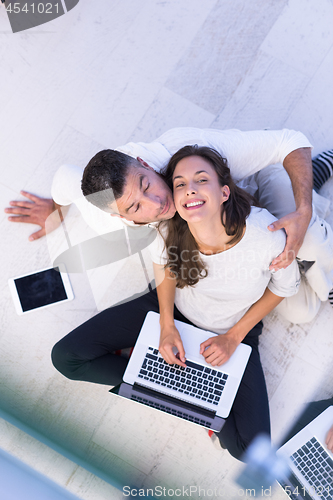 Image of couple using tablet and laptop computers top view