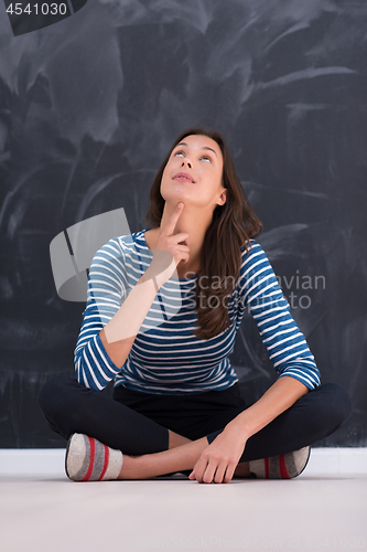 Image of woman sitting in front of chalk drawing board