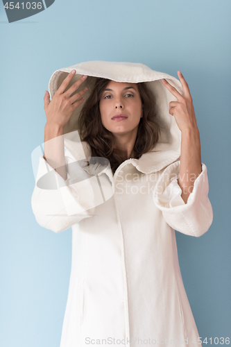 Image of woman in a white coat with hood isolated on blue background