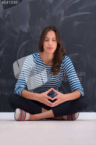 Image of woman sitting in front of chalk drawing board