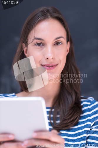 Image of woman using tablet  in front of chalk drawing board