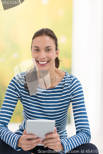 Image of young women using tablet computer on the floor