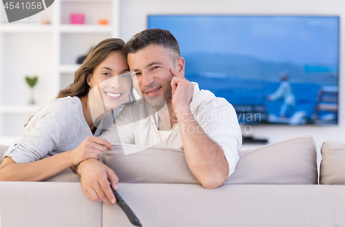 Image of Young couple on the sofa watching television