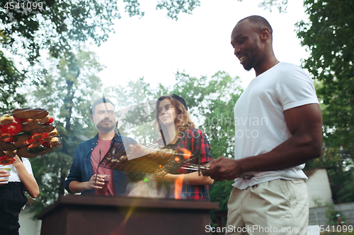 Image of Group of friends making barbecue in the backyard. concept about good and positive mood with friends