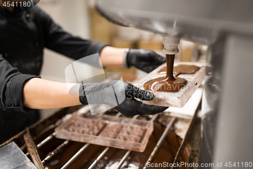 Image of confectioner makes chocolate candies at sweet-shop