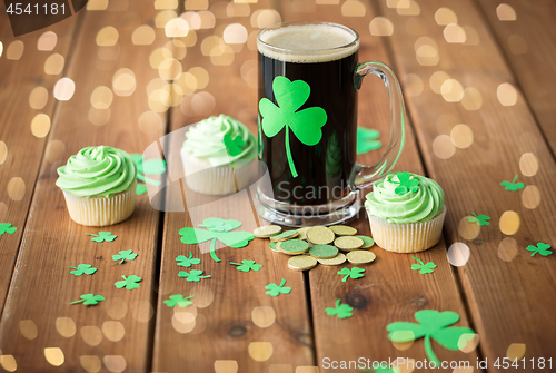 Image of shamrock on glass of beer, green cupcake and coins