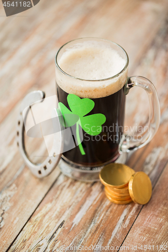 Image of shamrock on glass of beer, horseshoe and coins