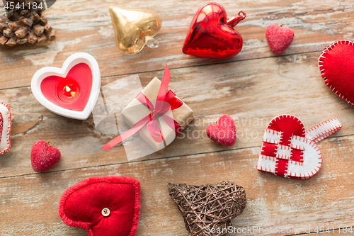 Image of christmas gift, heart shaped decorations, candle