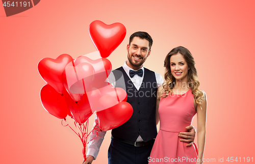 Image of happy couple with red heart shaped balloons