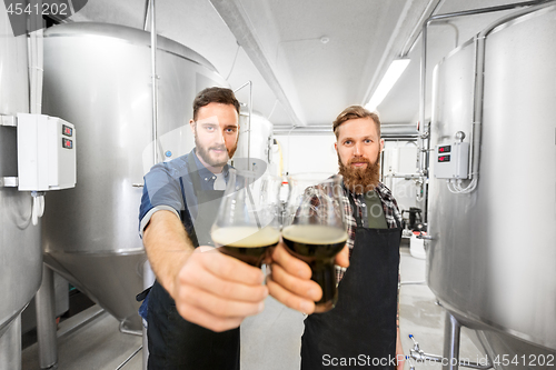 Image of brewers clinking glasses of craft beer at brewery