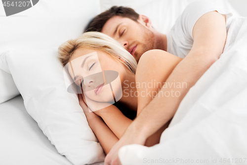 Image of happy couple sleeping in bed at home