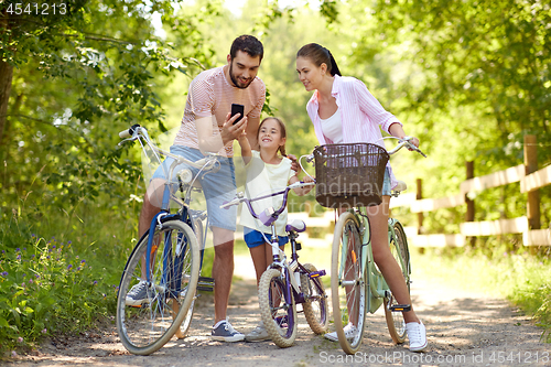 Image of family with smartphone and bicycles in summer park