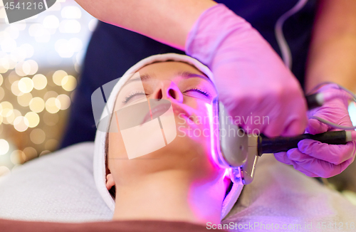 Image of young woman having face microdermabrasion at spa